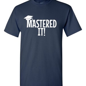 K&ouml;nnte beinhalten: Marineblaues T-Shirt mit dem wei&szlig;en Schriftzug "MASTERED IT!" und einer Abschlusskappe. Das T-Shirt hat einen Rundhalsausschnitt.