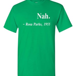 May include: A bright green t-shirt with the word "Nah." printed in white, followed by "- Rosa Parks, 1955." This short-sleeved tee is a bold statement piece, perfect for casual wear. The text is centered on the chest.