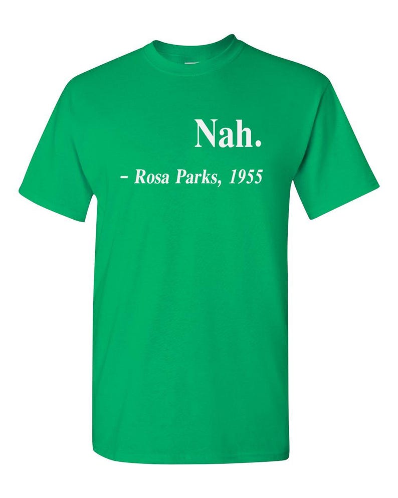 May include: A bright green t-shirt with the word "Nah." printed in white, followed by "- Rosa Parks, 1955." This short-sleeved tee is a bold statement piece, perfect for casual wear. The text is centered on the chest.