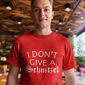May include: A red t-shirt with white text that reads "I don't give a Schnitzel".