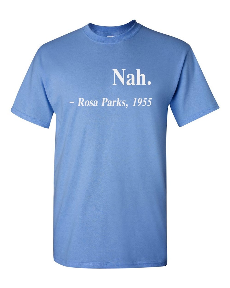 May include: Light blue t-shirt with the text "Nah." and "- Rosa Parks, 1955" printed in white. The shirt has short sleeves and a crew neck.
