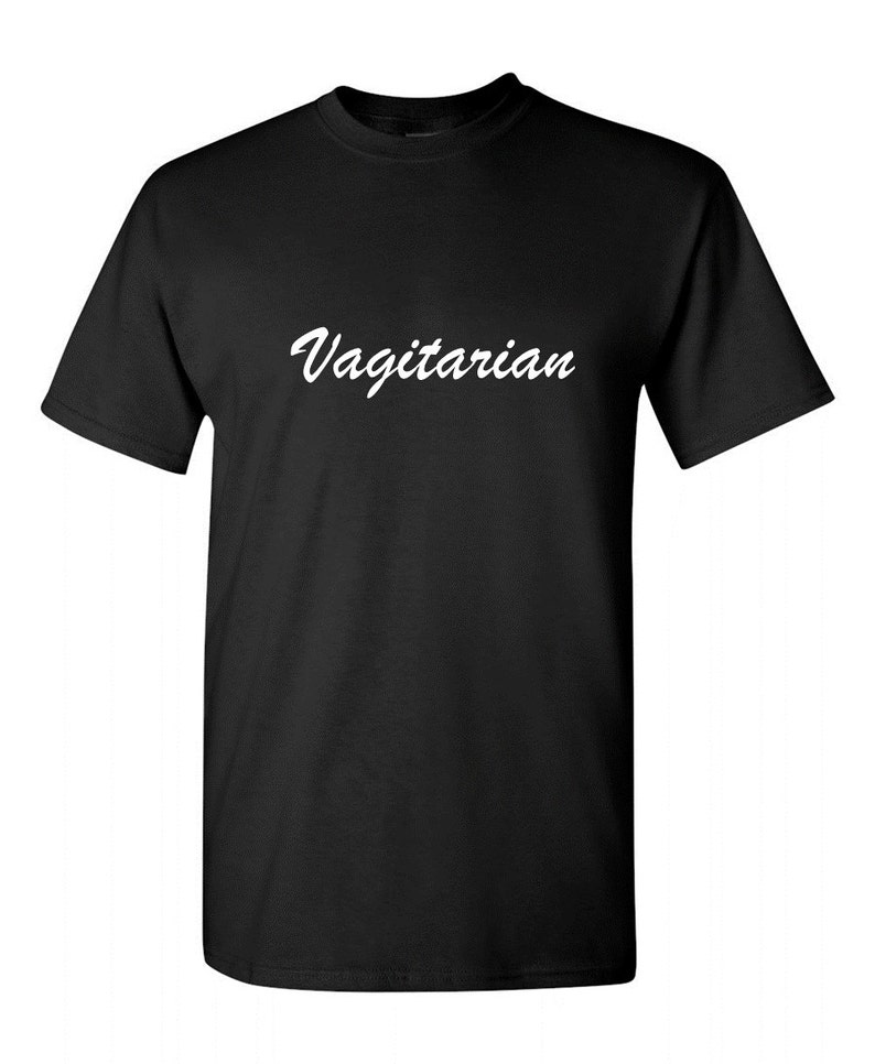 May include: Black t-shirt with the word "Vagitarian" printed in white script across the chest. The shirt has short sleeves and a crew neck. The fabric appears to be a soft cotton blend.
