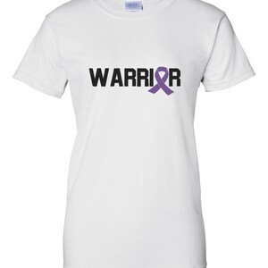 Puede incluir: Camiseta blanca con la palabra "WARRIOR" en letras negras y una cinta morada de concienciaci&oacute;n que reemplaza la letra "R". La camiseta est&aacute; hecha de un material suave y c&oacute;modo.