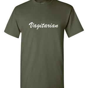 May include: Olive green t-shirt with the word "Vagitarian" in white script across the chest. The short-sleeved shirt is made of a soft material and has a crew neck.