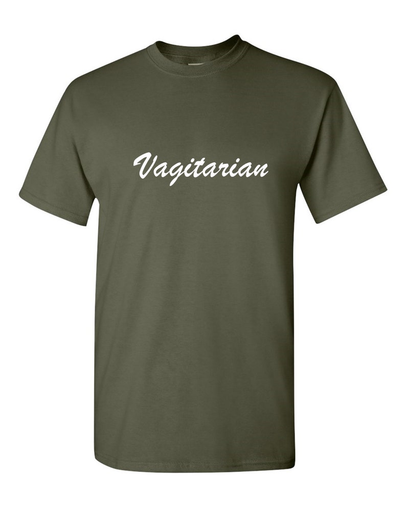 May include: Olive green t-shirt with the word "Vagitarian" in white script across the chest. The short-sleeved shirt is made of a soft material and has a crew neck.