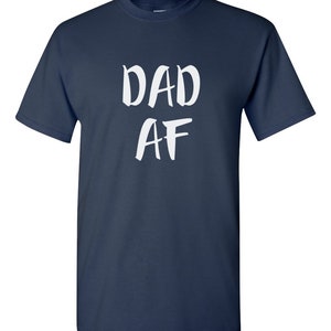 Peut inclure: T-shirt bleu marine avec l'inscription blanche "DAD AF" dans un style manuscrit. Le t-shirt a des manches courtes et un col rond.