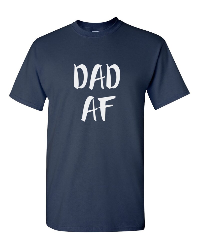 Peut inclure: T-shirt bleu marine avec l'inscription blanche "DAD AF" dans un style manuscrit. Le t-shirt a des manches courtes et un col rond.