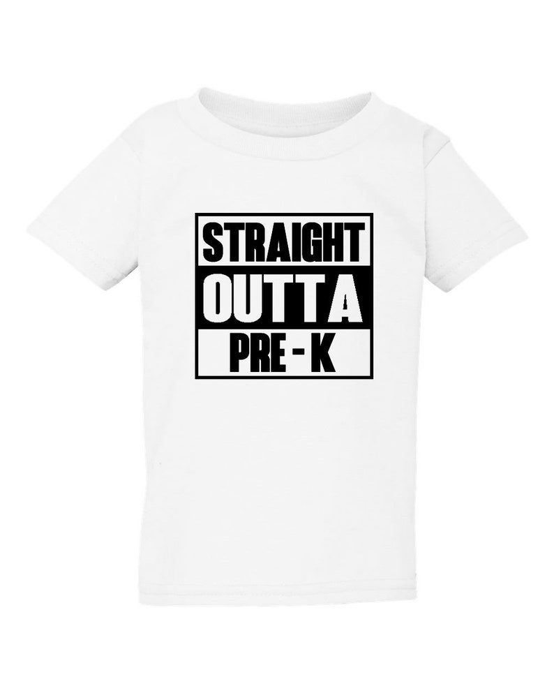 May include: White t-shirt with the text "STRAIGHT OUTTA PRE-K" in a black, bold font. The text is arranged in three lines within a black rectangular box. The shirt is a short-sleeved, crew neck style.