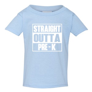 May include: A light blue toddler t-shirt with the text "STRAIGHT OUTTA PRE-K" in white block letters. The text is centered on the front of the shirt. The shirt has short sleeves and a crew neck.
