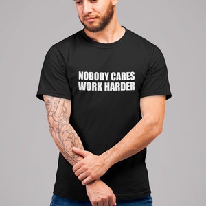 May include: A black t-shirt with white text that reads "Nobody Cares Work Harder".
