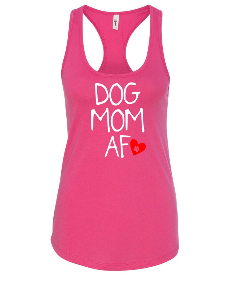 May include: A bright pink racerback tank top with the words "DOG MOM AF" in white block letters. A red heart with a paw print is below the text. The tank top has a scoop neck and a racerback design.