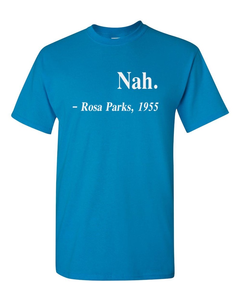 May include: A turquoise t-shirt with the word "Nah." printed in white, followed by "- Rosa Parks, 1955." The shirt is a short-sleeved crew neck style. The text is centered on the front of the shirt.