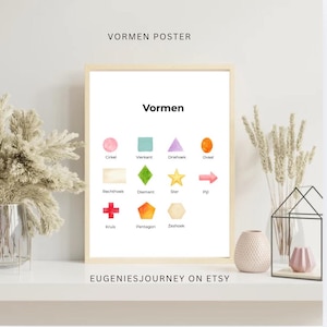 Op de afbeelding: Een ingelijste poster met het woord "Vormen" en diverse kleurrijke geometrische vormen. De vormen omvatten een cirkel, vierkant, driehoek, ovaal, rechthoek, ruit, ster, pijl, kruis, vijfhoek en zeshoek. De tekst "VORMEN POSTER" staat bovenaan.