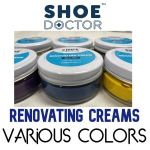 Op de afbeelding: Schoenpoetsglazen in verschillende kleuren, waaronder paars, blauw, geel en wit. De glazen zijn gelabeld met "Shoe Doctor Renovating Cream" en "50ml Net".