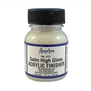 以下が含まれることがあります： Angelus Satin High Gloss Acrylic Finisherが入った透明なプラスチックボトル。黒い蓋が付いています。ボトルのラベルは青と白で、「Angelus No. 615 Satin High Gloss Acrylic Finisher」と使用方法が書かれています。ボトルには1液量オンスまたは29.5ミリリットルの製品が入っています。