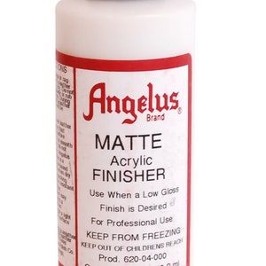 May include: A 4-ounce bottle of Angelus Brand Matte Acrylic Finisher. The bottle is white with a red label that says "Matte Acrylic Finisher" and "Use When a Low Gloss Finish is Desired". The label also says "Keep From Freezing" and "Keep Out of Children's Reach".