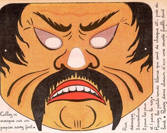 May include: A vintage paper mask with a fierce, stylized face. The mask features a large black mustache, a red open mouth, and white eye cutouts. Instructions in French are printed on the mask, suggesting it's a craft project. The mask is colored in shades of orange, black, and white.