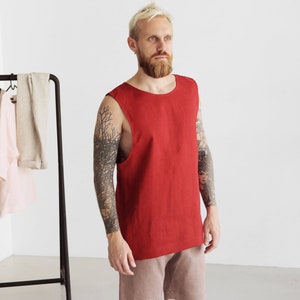 May include: A red sleeveless linen tank top with a round neckline. The tank top is made of a lightweight, breathable fabric and is perfect for warm weather.