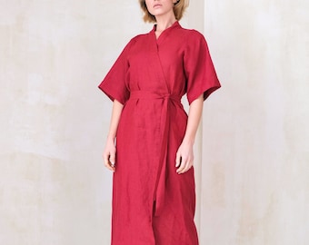 May include: A long, red linen wrap dress with a self-tie belt. The dress has a relaxed fit and a V-neckline.
