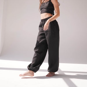 May include: A black linen crop top and matching wide-leg pants. The top has a halter neckline and a tie closure at the back. The pants have an elastic waistband.