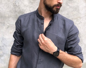 May include: A charcoal gray linen shirt with a mandarin collar and long sleeves. The shirt has a button-up front and is paired with a black wristwatch. The fabric appears to be lightweight and breathable.