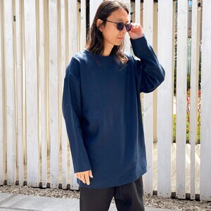 May include: A navy blue long-sleeved shirt with a relaxed fit. The shirt has a crew neck and is made of a soft, comfortable fabric.