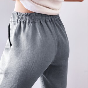Op de afbeelding: Grijze linnen broek met een elastische tailleband. De broek is losjes gesneden en heeft een ontspannen stijl.