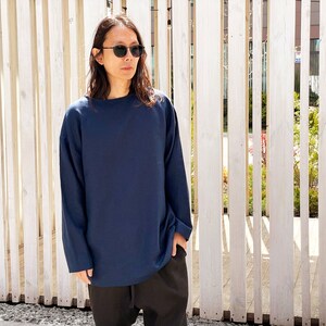 May include: A navy blue long-sleeved shirt with a relaxed fit. The shirt has a round neckline and is made of a soft, comfortable fabric.