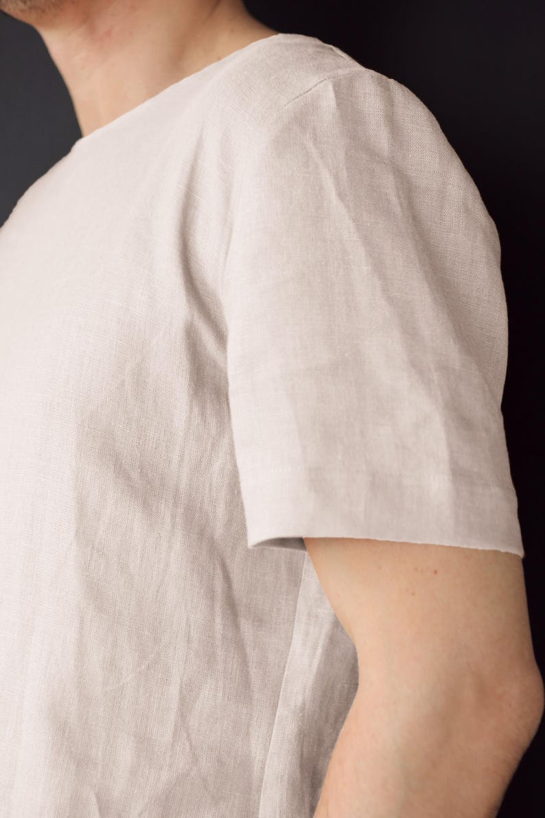 May include: A light beige linen t-shirt with short sleeves.