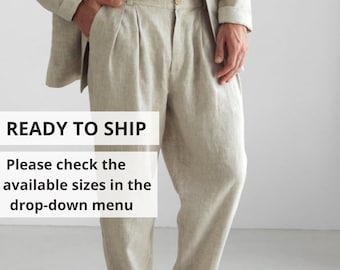 May include: A man is wearing a light beige linen blazer and matching pants. The pants have pleats and a relaxed fit. The man is wearing brown leather sandals. The text "READY TO SHIP" and "Please check the available sizes in the drop-down menu" is displayed on the image.