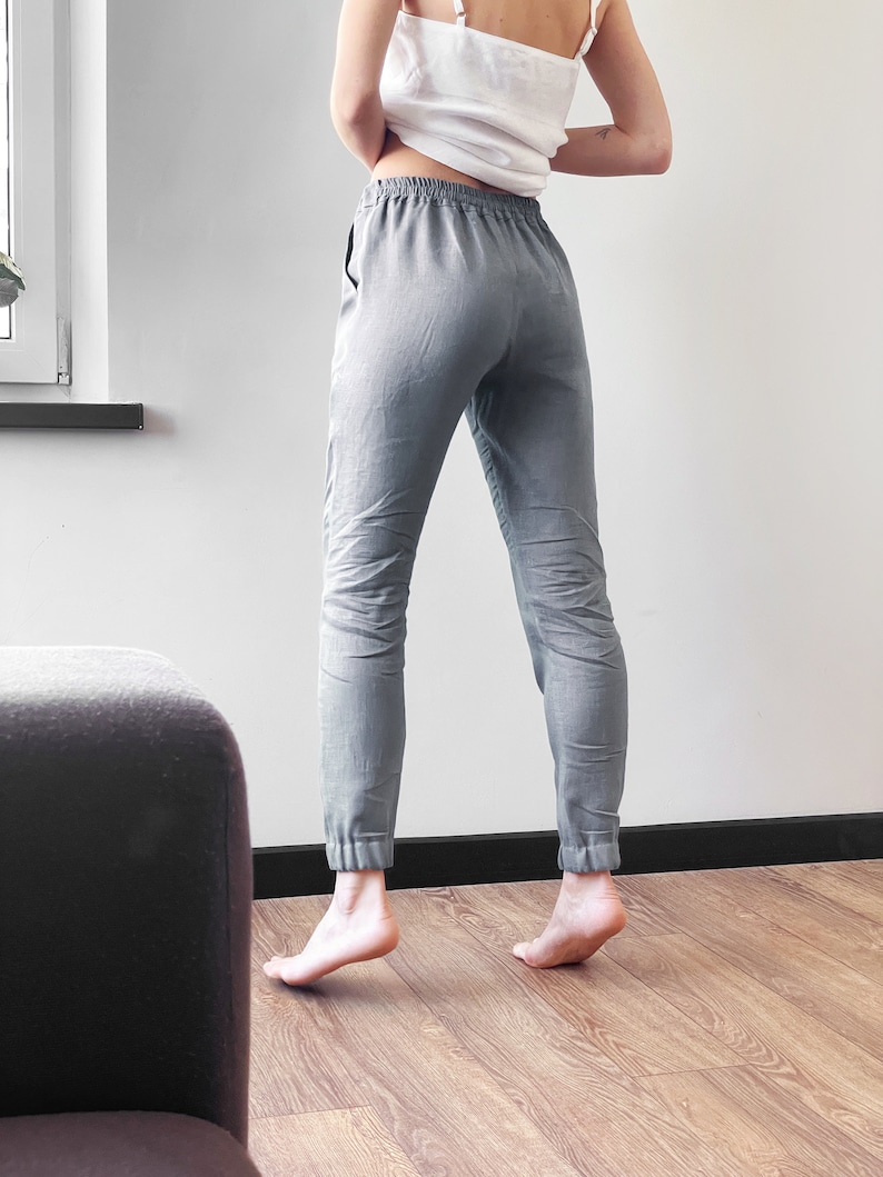 Op de afbeelding: Grijze linnen broek met een trekkoord in de taille en getailleerde pijpen. De broek is losjes gesneden en comfortabel.