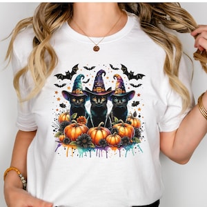 Pode incluir: Três gatos pretos usando chapéus de bruxa e sentados em um leito de abóboras laranja e flores pretas. Os gatos são cercados por morcegos e estrelas. A imagem tem um efeito de aquarela.