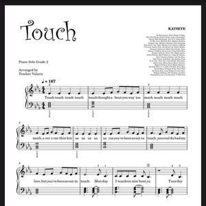 以下が含まれることがあります： KATSEYEの「Touch」のピアノソログレード2の楽譜。タイトルは装飾的なフォントで書かれています。楽譜にはト音記号とヘ音記号があり、歌詞が散りばめられています。