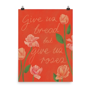 Puede incluir: Un fondo naranja con el texto "Give us bread but give us roses" escrito en cursiva blanca. El fondo está decorado con rosas rosas.