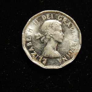 1953 Canada 5 cent coin ( near leaf )
