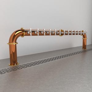 May include: A copper beer tap system with 16 taps, mounted on a wall with a drain in the floor. The taps are all in a row and are made of polished metal.