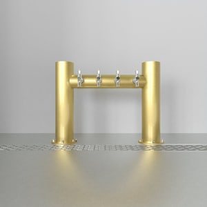 May include: A gold metal beer tap system with four taps. The taps are mounted on a horizontal bar that is supported by two vertical columns. The system is mounted on a stainless steel surface.