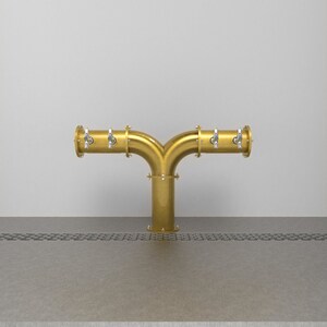 May include: A gold-colored metal beer tap with four spouts, mounted on a counter.