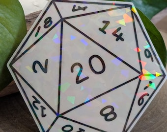 May include: A white, multi-sided die with black numbers and lines. The die has a holographic, iridescent effect. The number 20 is prominently displayed on one side. The die is likely used for tabletop role-playing games.
