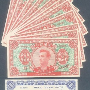 May include: A stack of ten red and green paper bills with Chinese characters and a portrait of James Dean. The top bill is a blue and white Hell Bank Note with the text "E64865 HELL BANK NOTE" and "1000000".