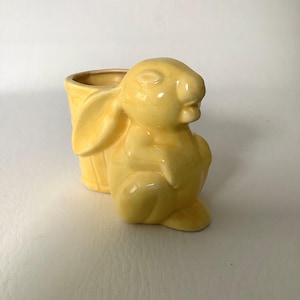 Könnte beinhalten: Eine weiße Keramik-Tasse mit schwarzem Henkel und dem Text "But First, Coffee" in schwarzer, fetter Schrift. Die Tasse steht auf einer weißen Oberfläche.