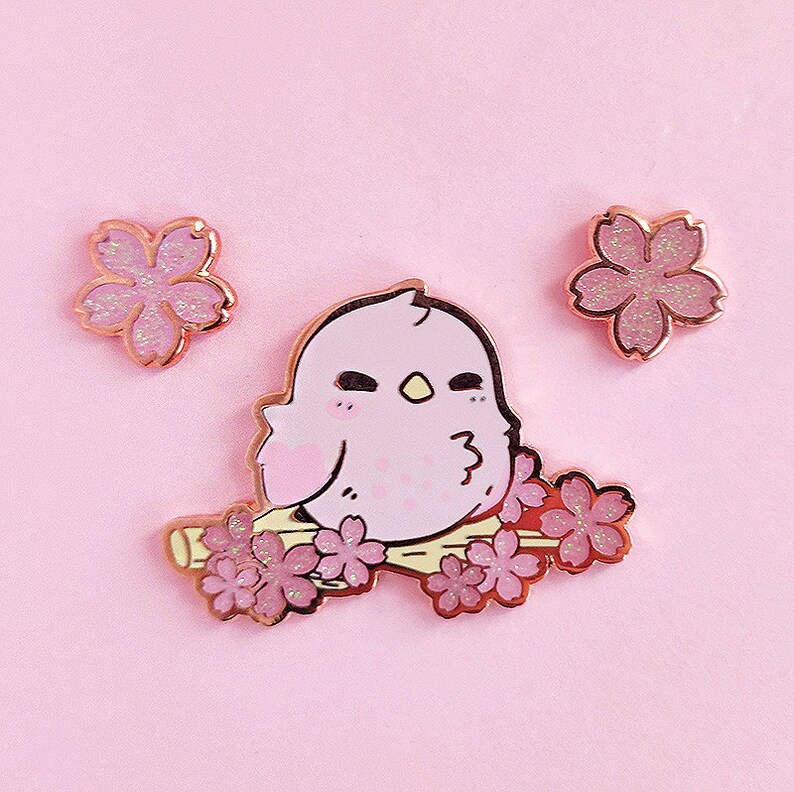 A pink bird enamel pin.