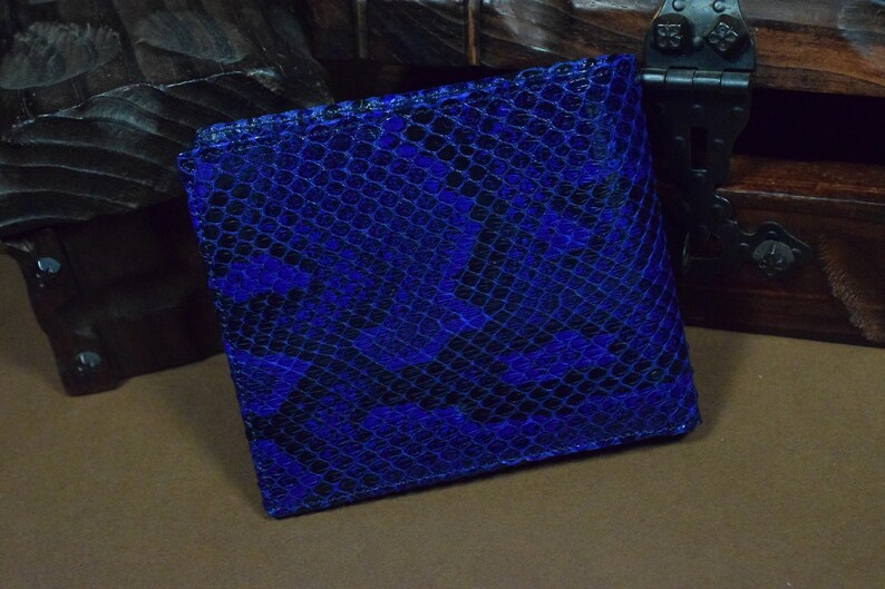 Peut inclure: Un portefeuille en cuir de serpent bleu avec un motif textur&eacute;.