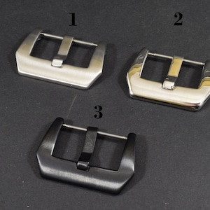 May include: Three watch band buckles, one silver, one polished silver, and one black.