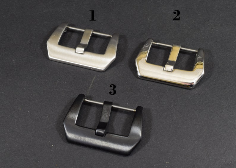 May include: Three watch band buckles, one silver, one polished silver, and one black.