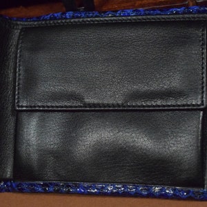 Peut inclure: Un portefeuille en cuir bleu avec un int&eacute;rieur noir et plusieurs emplacements pour cartes.