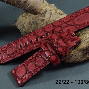 Op de afbeelding: Rood alligator-geëmbost lederen horlogeband met stiksels. Het band is 22/22 mm breed en 130/80 mm lang.