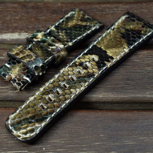 Peut inclure: Un bracelet de montre en cuir de serpent vert, noir et blanc avec des coutures blanches. Le bracelet est en cuir véritable et est conçu pour être utilisé avec une montre.