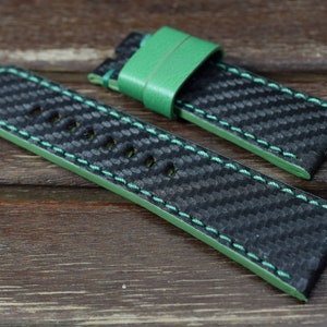 Puede incluir: Correa de reloj negra y verde con un patrón de fibra de carbono y costuras verdes.