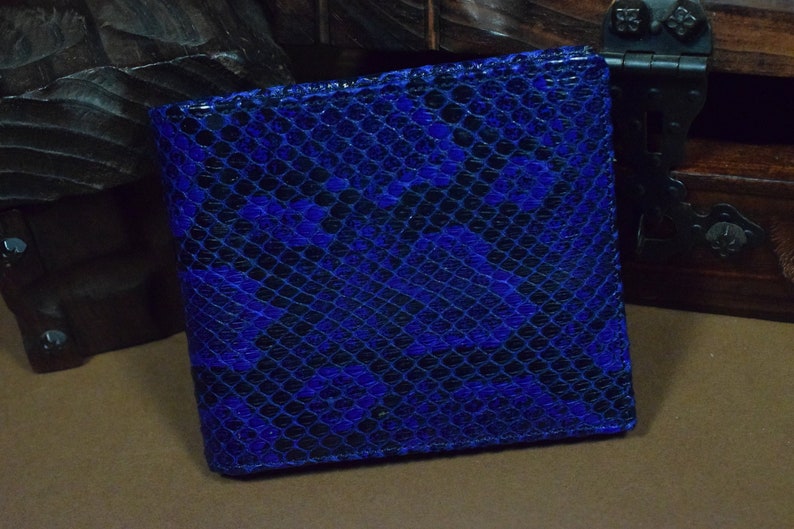 Peut inclure: Un portefeuille en cuir bleu avec un motif en peau de serpent.